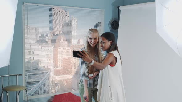 Backstage of the Photo Shoot Attractive Black Model Making Selfie with Pretty Makeup Artist