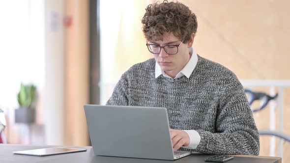 Young Man at Work Using Laptop