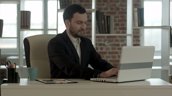 Businessman Finished Work in Front of a Laptop