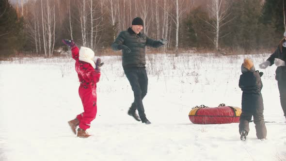 Family Throwing Snow on Each Other in Winter Time