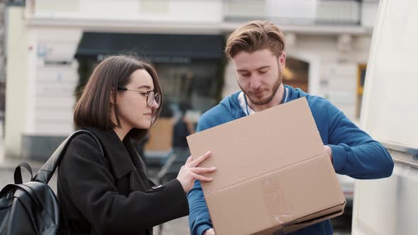 Delivery Man Checking Commodity of Paper Box Outside