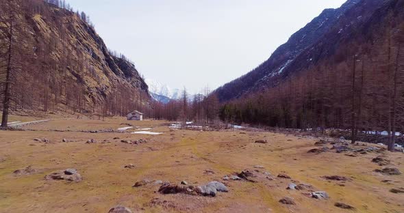 Aerial Flying Moving Forward on River Creek Near Lodge in Yellow Mountain Valley and Forest Woods