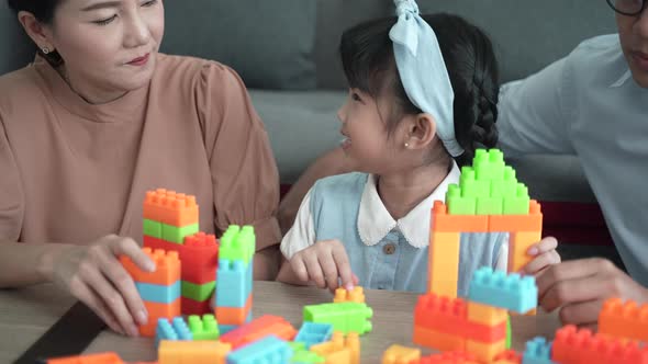 happy family at home, daughters with parents playing toy, playing to create learning of children