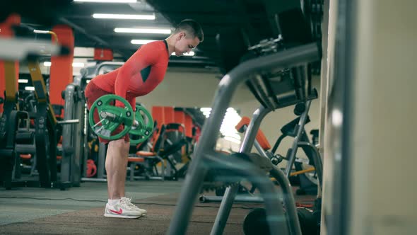 Male Athlete Exercises with Barbell. alt