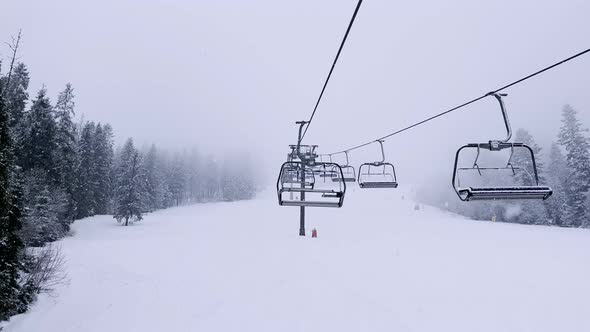 POV Empty Ski Lift Snowy Mountain Winter Forest with Chair Lift At The Ski Resort in Winter