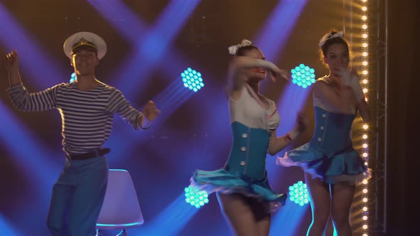 Three Pretty Women in Seductive Sailor Suits Dance Incendiaryly with Their Partner in a Sailor Cap