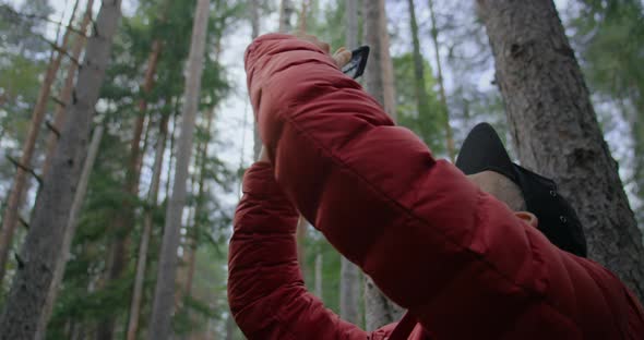 Urban Nomad Hipster Man Film on Phone in Forest