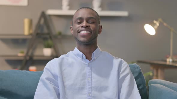 Portrait of African Man Showing Yes Sign While Sitting on Sofa