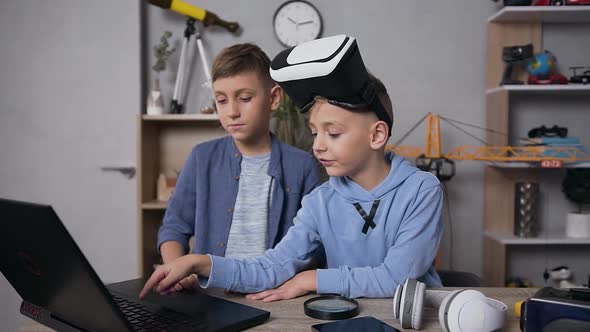 7-10 Aged Boy Choosing the Video Game on Computer to Play with His Friend Using VR