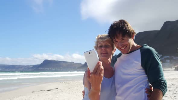 Mother and son taking selfie from mobile phone at beach