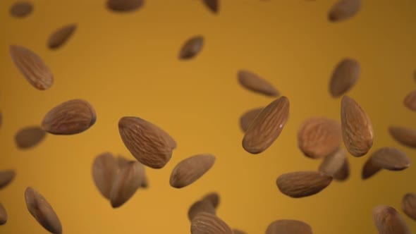 Delicious Almonds Are Bouncing and Rotating on the Yellow Background