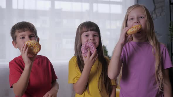Fun Little Friends Stand with Donuts in Their Hands While Having Snack Half an Active Game at
