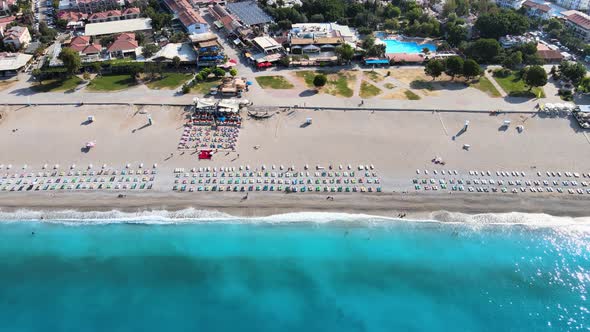 Shooting from a drone of a panorama of the beach line with umbrellas and sun loungers in the Mediter