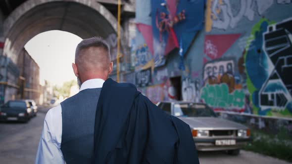 Handsome Bearded Mature Man in Suit Walking Outdoors in City with Graffiti Background Slow Motion