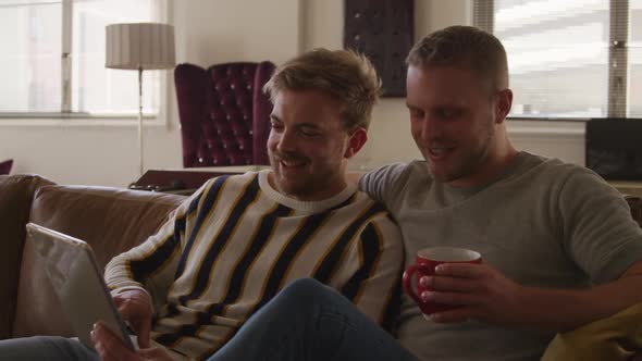 Caucasian male couple in social distancing in their sofa at home