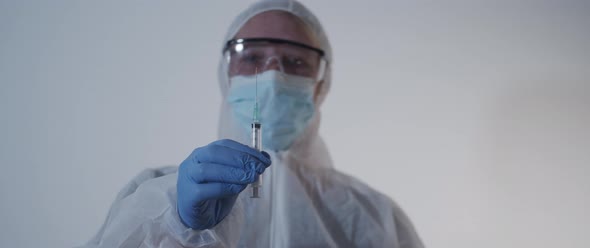 woman in protection gear holding a syringe