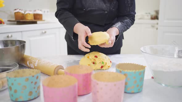 a Woman Cook Lays Out Dough in Paper Molds for Baking Easter Cakes