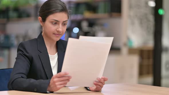 Indian Businesswoman Reading Documents in Office 