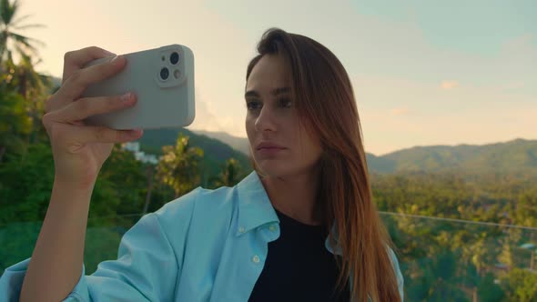 Happy Tourist is Pivoting in One Direction to Take a Panorama of the Topical Forest with Her