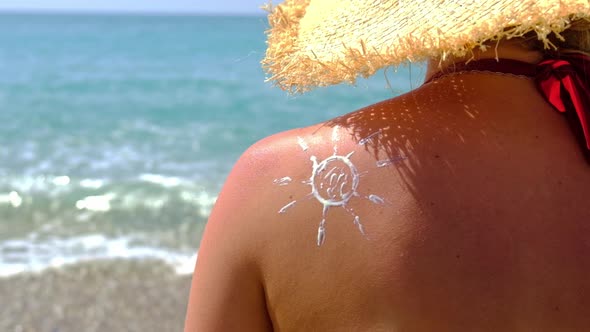 Woman on the Beach Smears Sunscreen