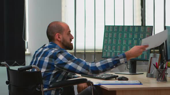 Manager in Wheelchair Comparing Financial Data From Documents