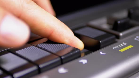 Pushing Play Button on a Vintage Tape Recorder