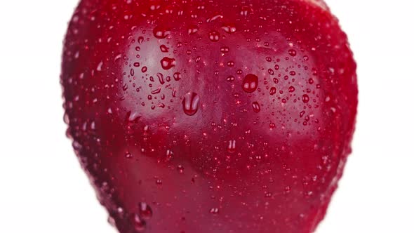 Juicy Red Apple with Water Drops Turns Left Side on White