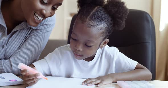 African Ethnic Mom Teaching Helping Learning Distance Daughter Child to Do Homework