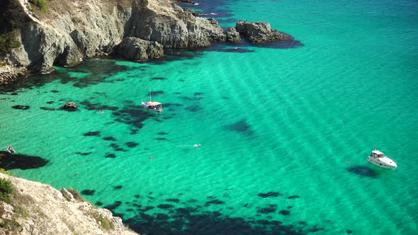 Boats and Yachts in the Rocky Bay with Crystal Clear Azure Sea on a Sunny Day