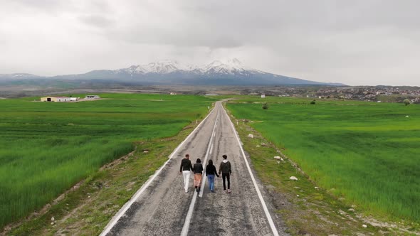 Drone footage: Travelers Walking Along A Road	