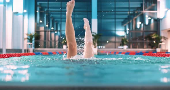 Female Swimmer in the Pool Young Woman Perform the Elements of Synchronized Swimming View of Legs