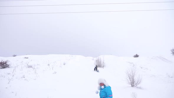 Happy Girl Slides Through Snow on Sled, Beautiful Young Woman Slides Down