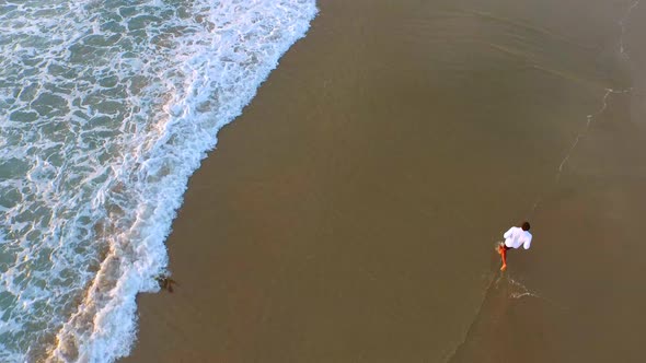 Aerial shot of young man running on the beach.