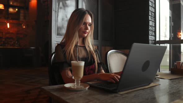 Beautiful Woman Working on Her Laptop on a Stylish Urban Restaurant