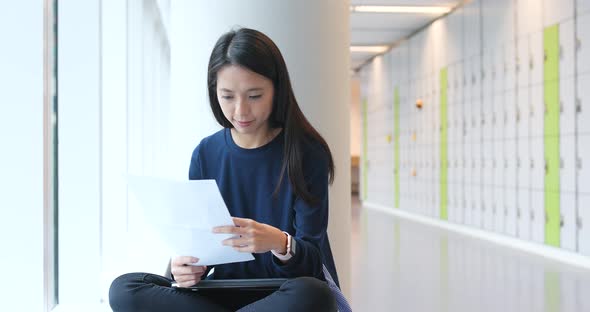 Woman reading on paper note in university campus