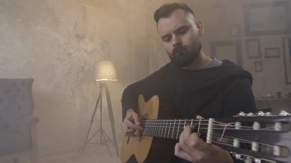 Young Man Playing Guitar in the Room