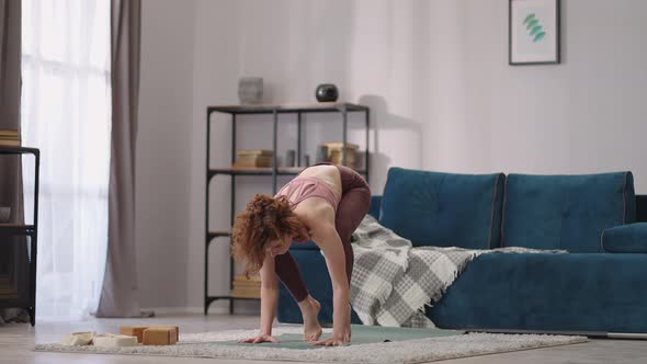 Woman is Doing Handstand During Home Yoga Training Performing Asana for Balance and Strength