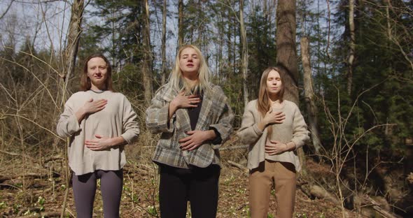 meditation of three girls in the forest that keep your hands on your chest and stomach and breathe