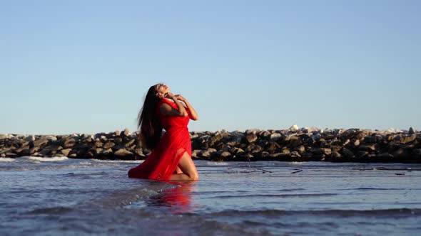 Brunette with Long Hair Runs Hands on Body in Red Dress