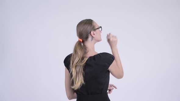 Rear View of Blonde Businesswoman Directing and Pointing Finger
