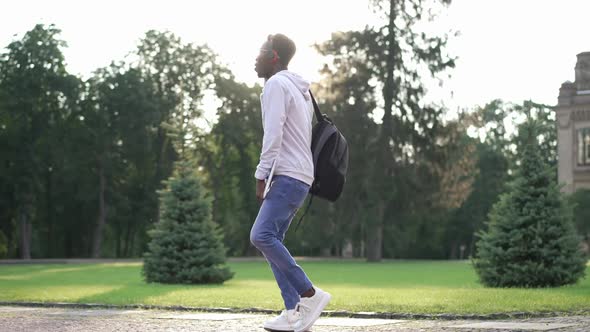 Wide Shot Happy Confident African American Student in Headphones Listening to Music Dancing in Slow