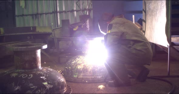 A Professional Welder Makes Steel Structures at the Factory