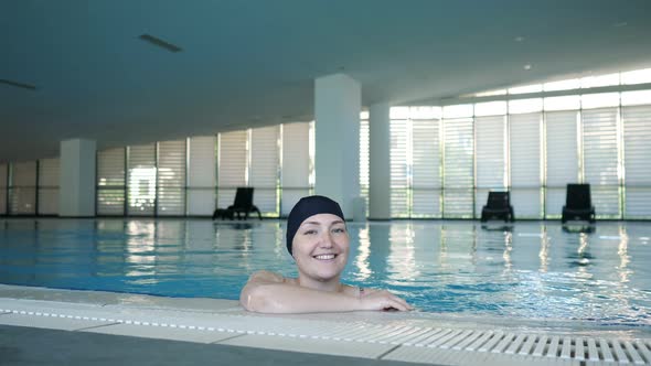 Young Woman in Cap in Swimming Pool