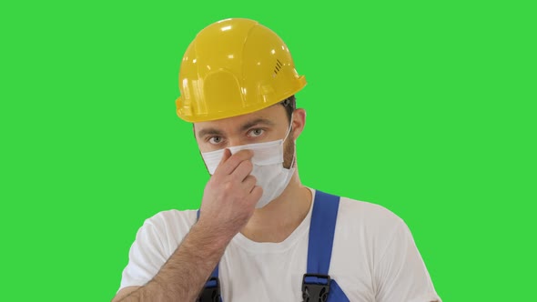 Ware the Mask! Masked Construction Man in Hardhat on a Green Screen, Chroma Key