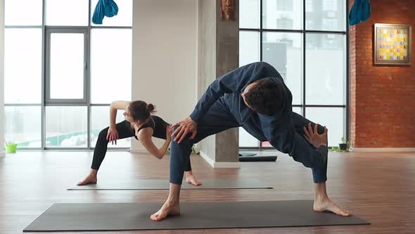 Man and Woman Practice Synchronously Stretch Exercise in Yoga Studio