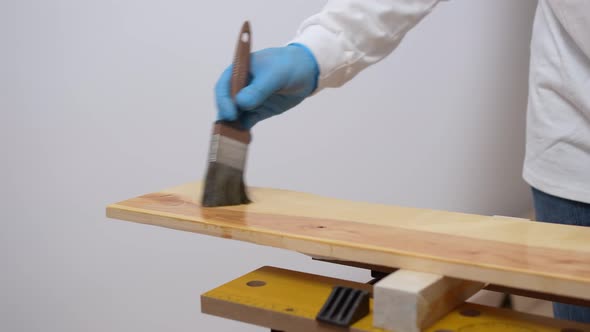 the Carpenter Covers the Wood with Oil with a Brush