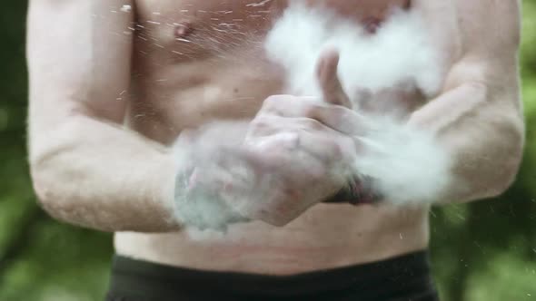 Medium Shot of a Muscular Thorso and a Pair of Hands with Talc Powder