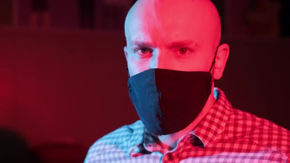 Man with Protective Medical Masklooking at Camera Flashing Red Blue Light