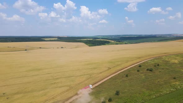 Aerial View of Cargo Truck Driving on Dirt Road Between Agricultural Wheat Fields Making Lot of Dust