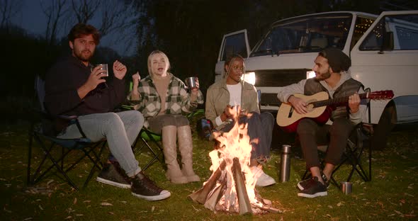 Multi Ethnic Freinds Warming By Camp Fire in Autumn